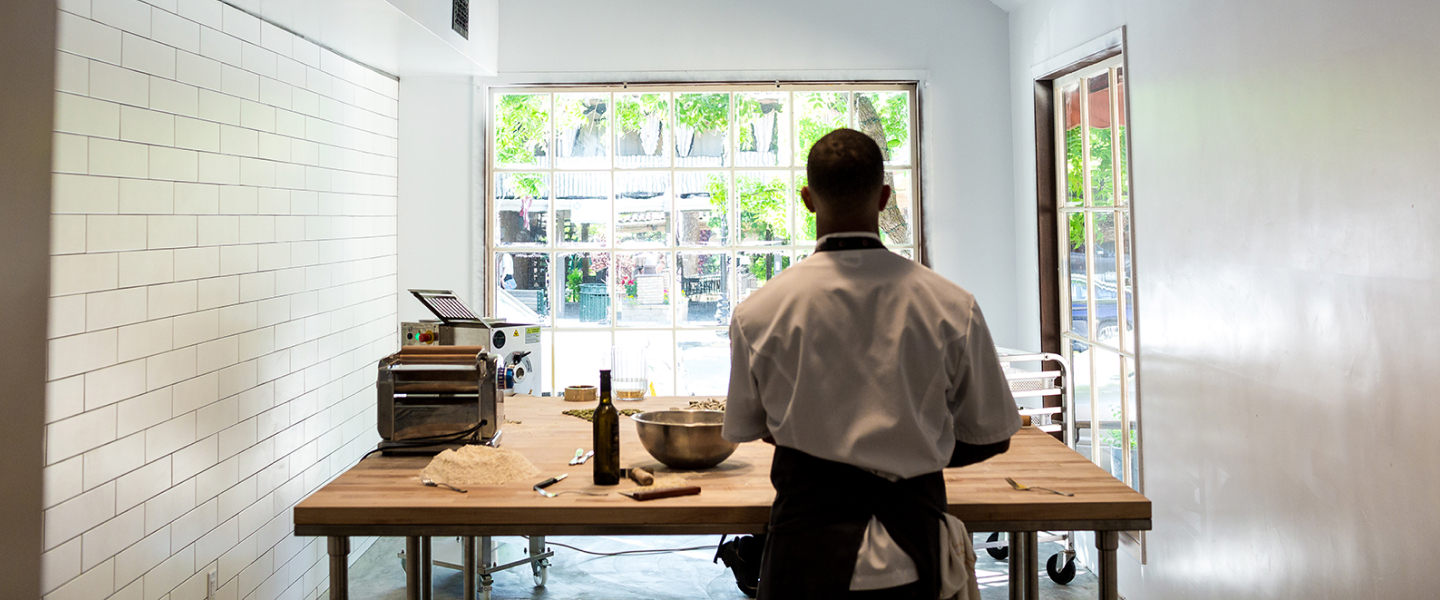 A cook making pasta in the kitchen